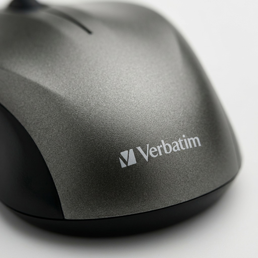 An extreme macro photograph of the Verbatim logo and graphite texture on the back of the mouse.